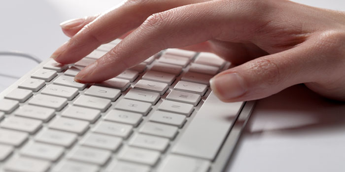 En hand hålls på ett tangentbord